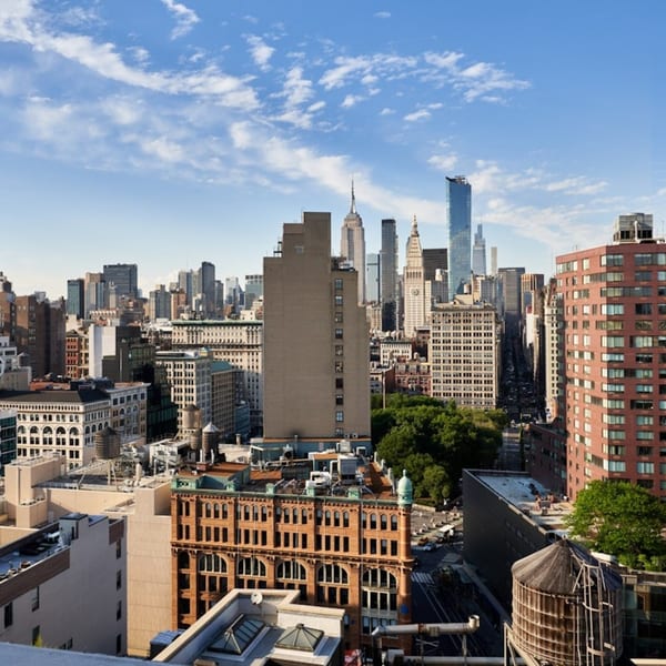 A high-angle view of the New York City skyline with various buildings under a blue sky.