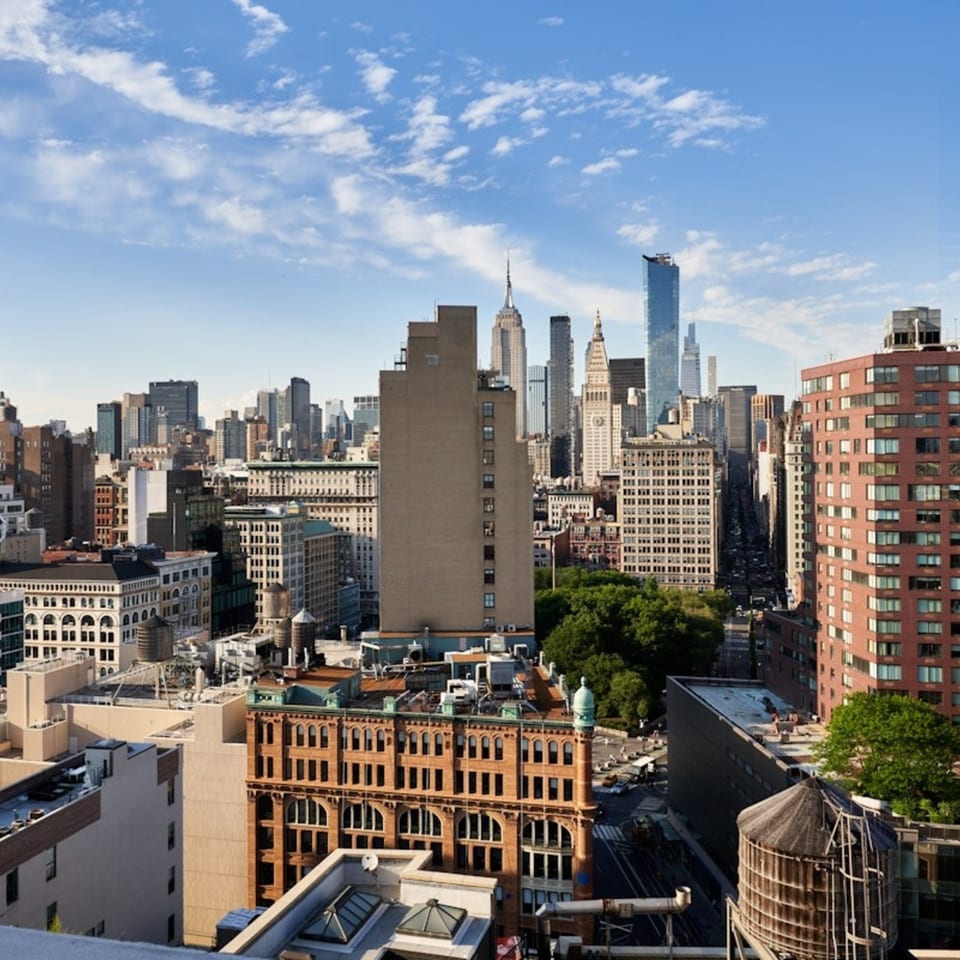 A high-angle view of the New York City skyline with various buildings under a blue sky.
